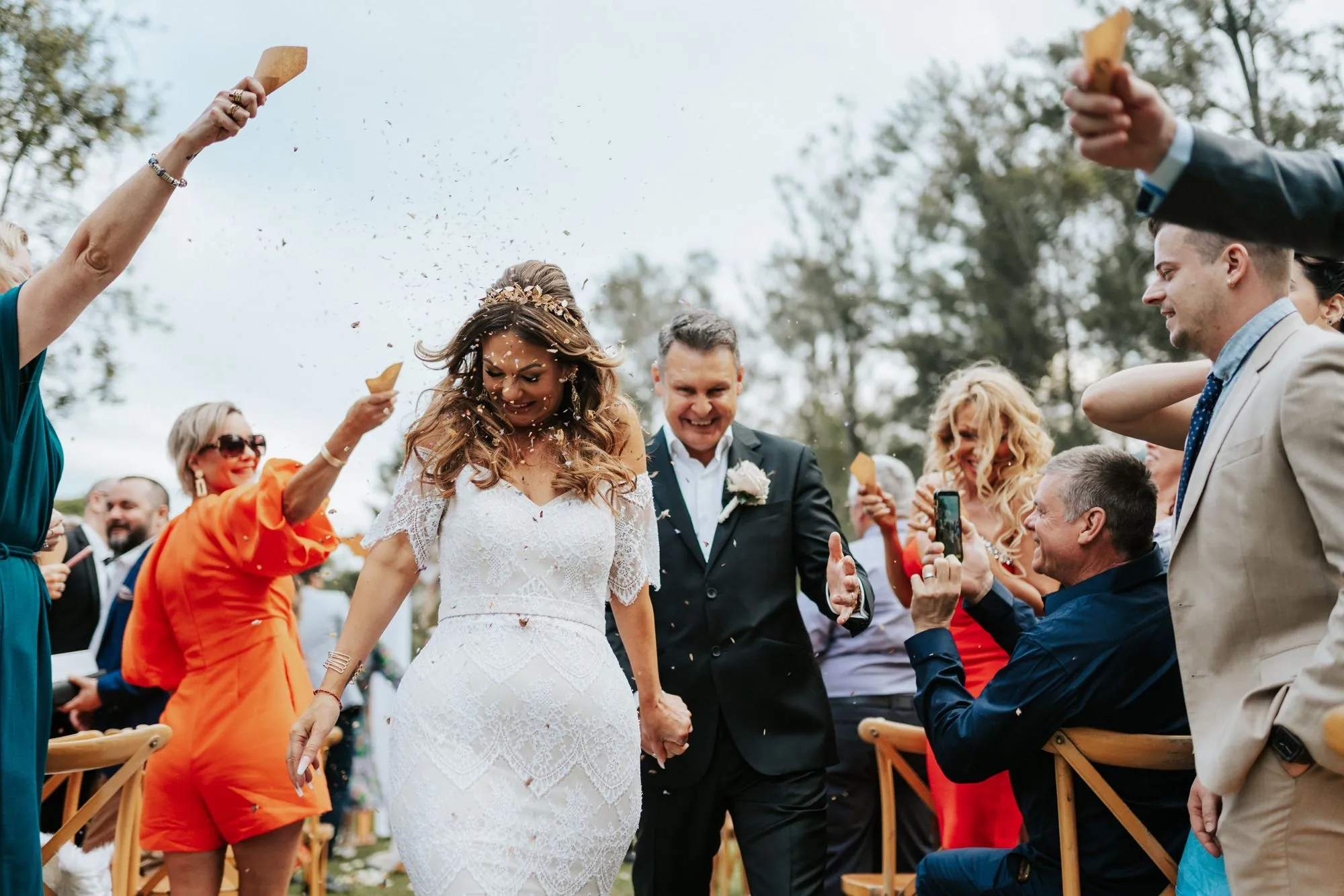Bride and groom walking through a confetti send-off at their wedding