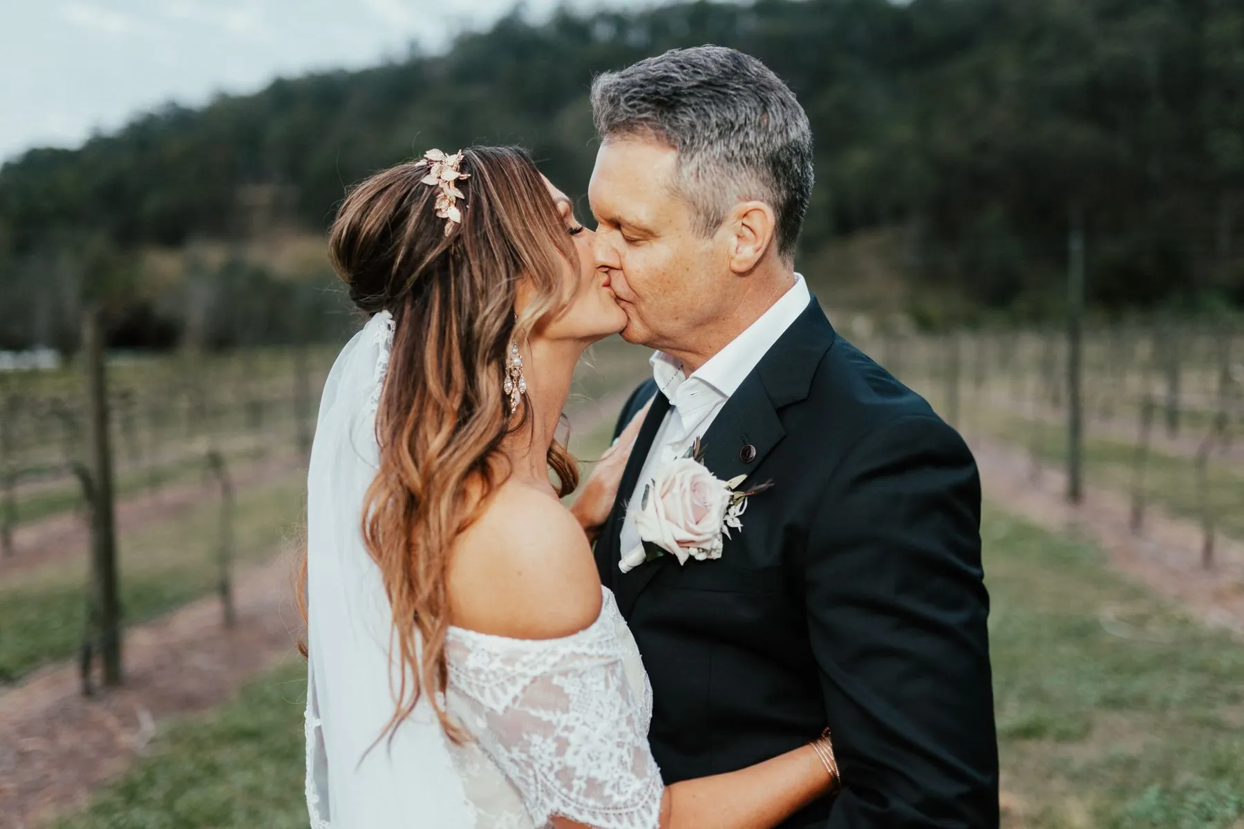 Bride and groom kiss in a Scenic Rim vineyard