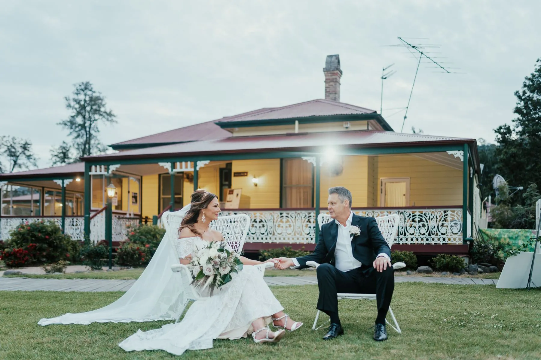 Couple on a vineyard homestead verandah at dusk